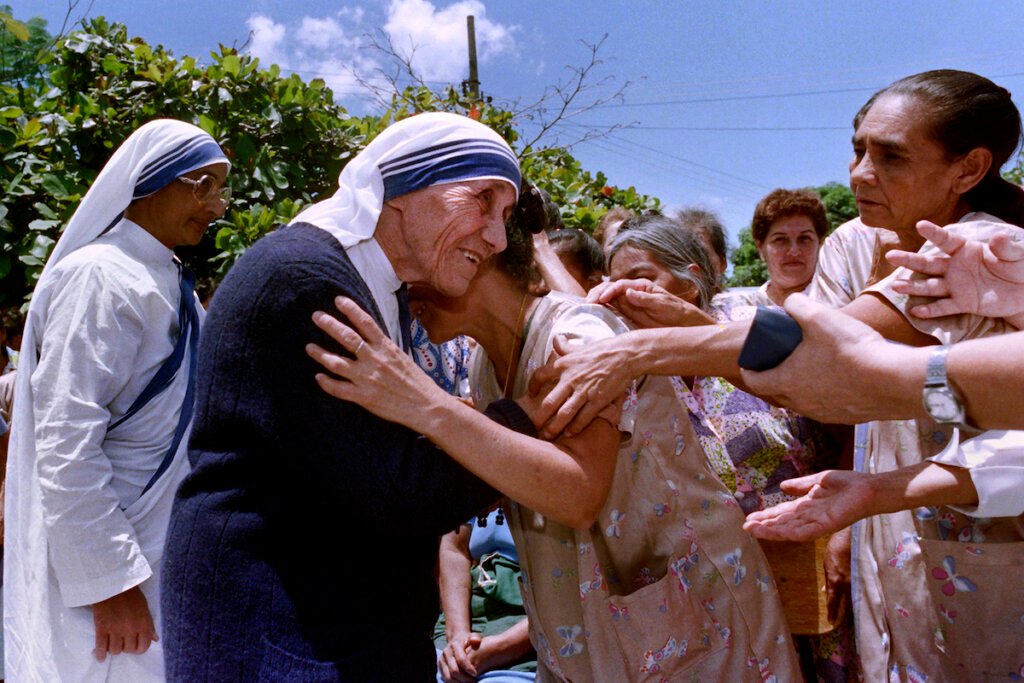 Mother Teresa hugs a patient on July 5, 1988 during her visit at the divine providence hospital in El Salvador during her three-days visit in San Salvador.  / AFP PHOTO / Ivan C. MONTECINOS